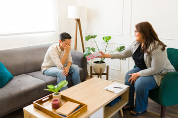 Depressed man crying during therapy and using tissues