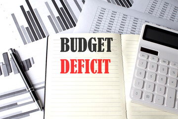 BUDGET DEFICIT text written on a notebook on chart and diagram