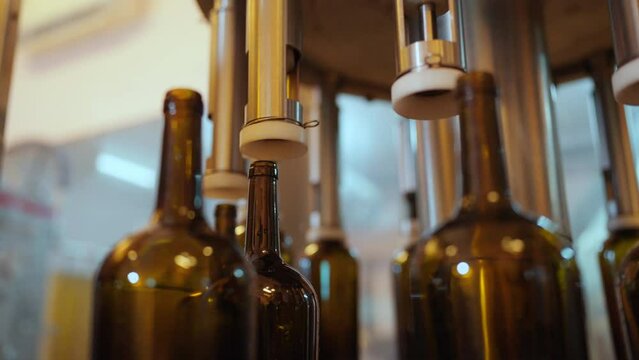 Liquor bottle washing machine in production conveyor line with quality control at wine factory. Winery or brewery liquor manufacturing industry and winemaking concept.