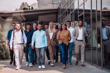 Obraz premium A diverse group of businessmen and colleagues walking together by their workplace, showcasing collaboration and teamwork in the company.