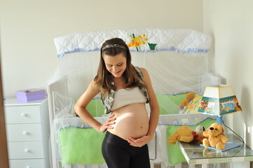 mulher gravida em quarto do bebê, maternidade com amor 