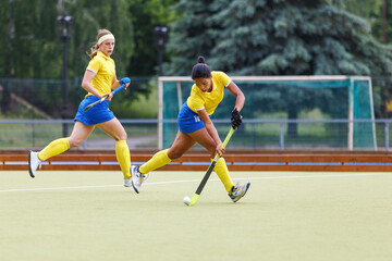Field hockey female player leading the ball in attack. Young woman playing in field hockey...