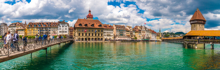 Lovely huge panorama picture of Lucerne's old town boulevard along the river Reuss with people on...