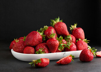 Ripe red strawberries on a black table