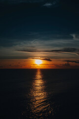 Fototapeta premium Bright orange sunset on the dark Indian Ocean on Bali island. Evening sunlight, fire sky, amazing view