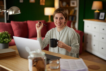 Happy female freelance professional working from home on laptop