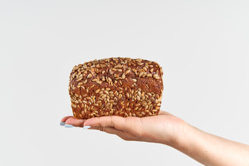 Homemade multigrain bread in woman hand over white background