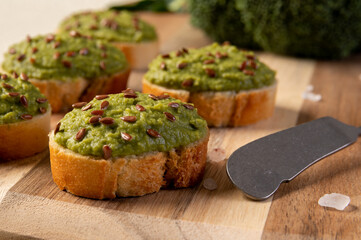 Mashed broccoli on slices of bread, sprinkled with flax seeds. Broccoli puree.