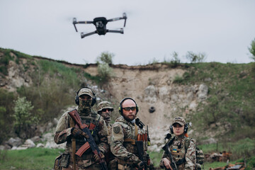 Armed Ukrainian militarymen using a drone