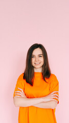 Obraz premium Radiant Joy: Beautiful Woman with Beaming Smile and Arms Crossed, Embracing Good Mood in Comfortable Attire - Vibrant Positivity on Pink Background.