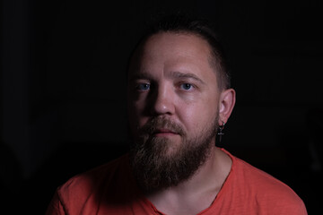 Dramatic low key portrait of a bearded man in a studio