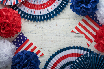 4th of July background. USA paper fans, Red, blue, white stars,  balloons, gold confetti on white wooden  background. Happy Labor Day, Independence or Presidents Day. American flag colors. Top view.