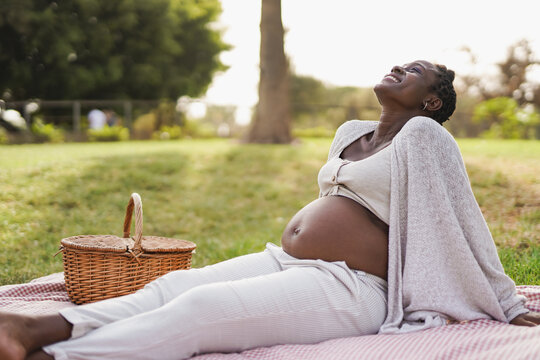 Happy pregnant african woman enjoy pic nic at city park