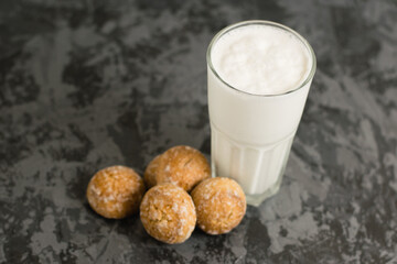 Flatlay, a delicious, refreshing summer drink in a glass, a milkshake made of milk and ice cream. Gingerbread on a dark table