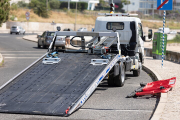 An empty car tow truck stands at the curb