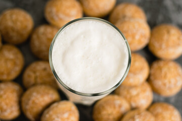 Flatlay, a delicious, refreshing summer drink in a glass, a milkshake made of milk and ice cream. Sweet foam cocktail close-up. Gingerbread on a dark table