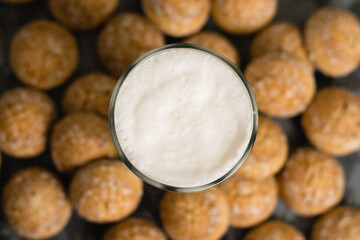 Flatlay, a delicious, refreshing summer drink in a glass, a milkshake made of milk and ice cream. Sweet foam cocktail close-up. Gingerbread on a dark table