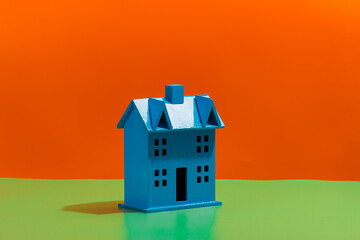 Blue plastic house on vibrant background