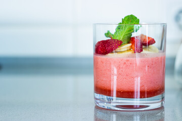 Light strawberry smoothie with banana and mint in a glass 