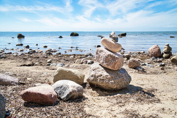 Stone pyramid on the Baltic Sea overlooking with blue sky and sunshine. Spiritual
