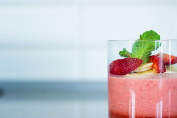 Light strawberry  smoothie with banana and mint in a glass 