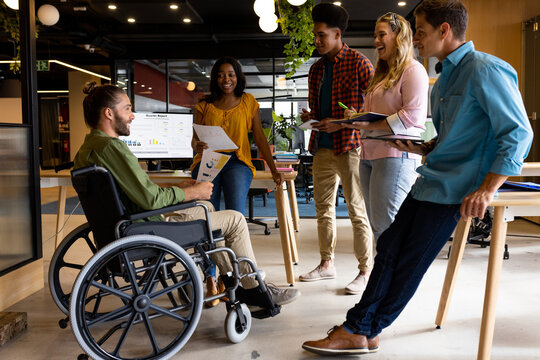 Diverse male and female colleagues in discussion at casual office meeting