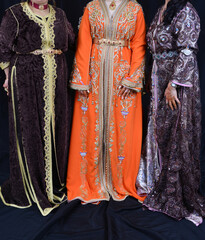Three Moroccan women wear traditional Moroccan caftans
