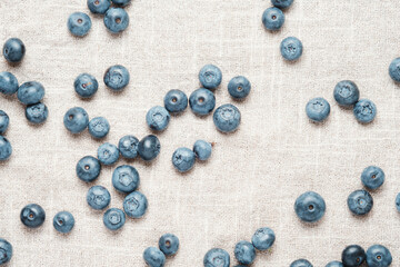 Fresh blueberries scattered on a linen napkin.