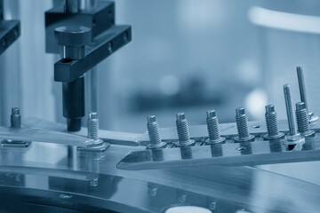 The quality control process of metal screw production line. - obrazy, fototapety, plakaty