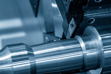 Fototapeta premium Closeup scene of the lathe tool insert with the metal shaft parts on CNC lathe.