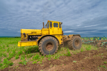 Spring photography, landscape with agricultural machinery, a tractor plows the land, plows a field,...