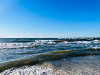 Blue seascape, waves on the sea, sandy coastline, empty beach