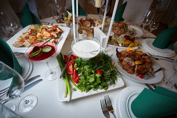 Festive buffet table with various dishes on a white tablecloth