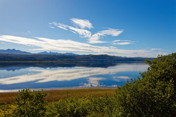 Obraz premium Late afternoon with cloud reflections over a large lake with reeds and waterfowl near Knysna, South Africa.