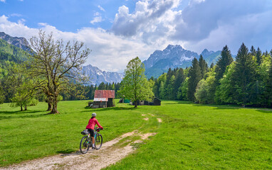 cheerful active senior woman on a E mountain bike tour at Vršič Pass in the Triglav National...