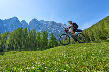 cheerful active senior woman on a E mountain bike tour at Vršič Pass in the Triglav National...
