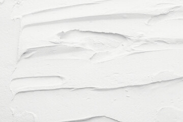 Decorative white putty background. Wall texture with filler paste applied with spatula, chaotic dashes and strokes over plaster.