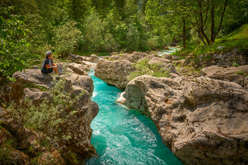 woman resting during a hiking tour along turquoise River Soca in the Triglav National Park of the...