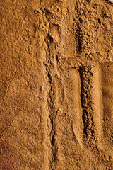 Decorative brown ocher putty background. Wall texture with filler paste applied with spatula, chaotic dashes and strokes over plaster. Creative design, stone pattern, cement.
