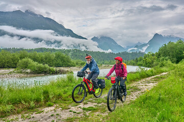active senior couple  on a e-bike tour in the Valley of River Soca, Triglav National Park near Bovec, Slovenia
