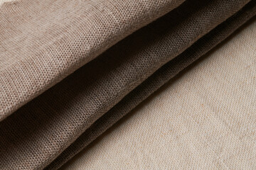 Linen in different textures and colors. Natural fabrics from organic flax and cotton in rolls, homespun textile handmade. Burlap and canvas for eco, rustic, boho, hygge decor .