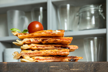 Homemade pizza waffle with tomato sauce, pepperoni, olives and parmesan cheese on a cutting board on the kitchen table