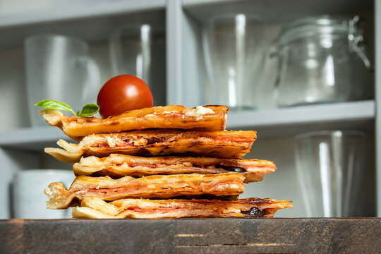 Homemade pizza waffle with tomato sauce, pepperoni, olives and parmesan cheese on a cutting board on the kitchen table
