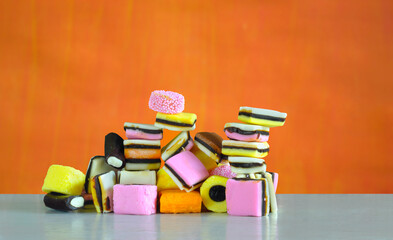 liquorice confectionery on orange background,multicolored and colorful sweet food,sweets or candy concept