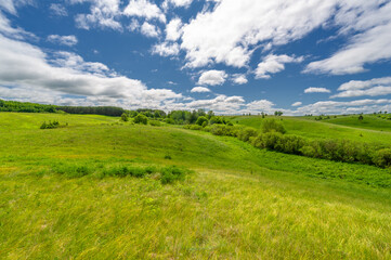 Fototapeta na wymiar Spring photography, meadows, fields, ravines, hills, rural landscape. A deep, narrow gorge with steep slopes. A naturally raised area of ​​land, not as high or craggy as a mountain.