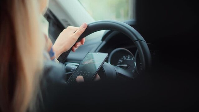 Woman texting on smartphone while driving car