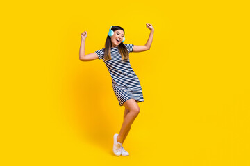 Fototapeta na wymiar Full length photo of cheerful crazy lady wear trendy outfit raise hands good mood listen track isolated on yellow color background