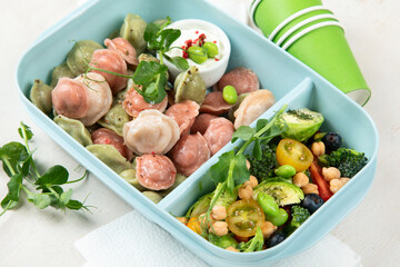 Vegetarian food. Colored dumplings in a plate/on board.