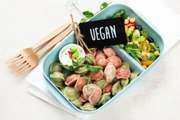 Vegetarian food. Colored dumplings in a plate/on board.