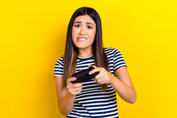 Photo of nervous young woman wear striped t-shirt hold gamepad video console playstation loser level isolated on yellow color background © deagreez